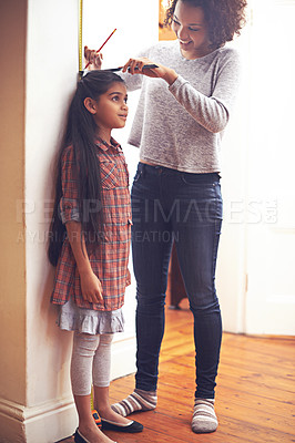 Buy stock photo Mother, child and measuring tape for height with ruler at wall for growth development in home, childhood or bonding. Female person, daughter and pencil in apartment for size checking, youth or parent