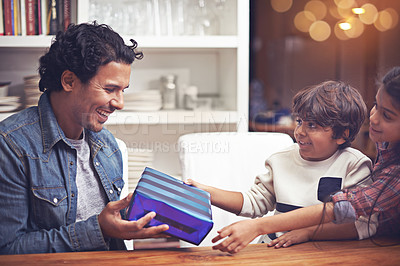 Buy stock photo Father, children and present giving in home for happy birthday congratulations, celebration or gratitude. Male person, siblings and gift parcel at table for vacation connection, family or living room