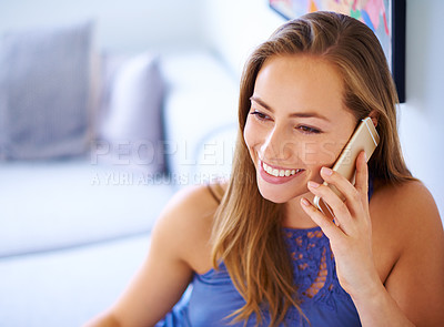 Buy stock photo Shot of a young woman talking on her cellphone at home