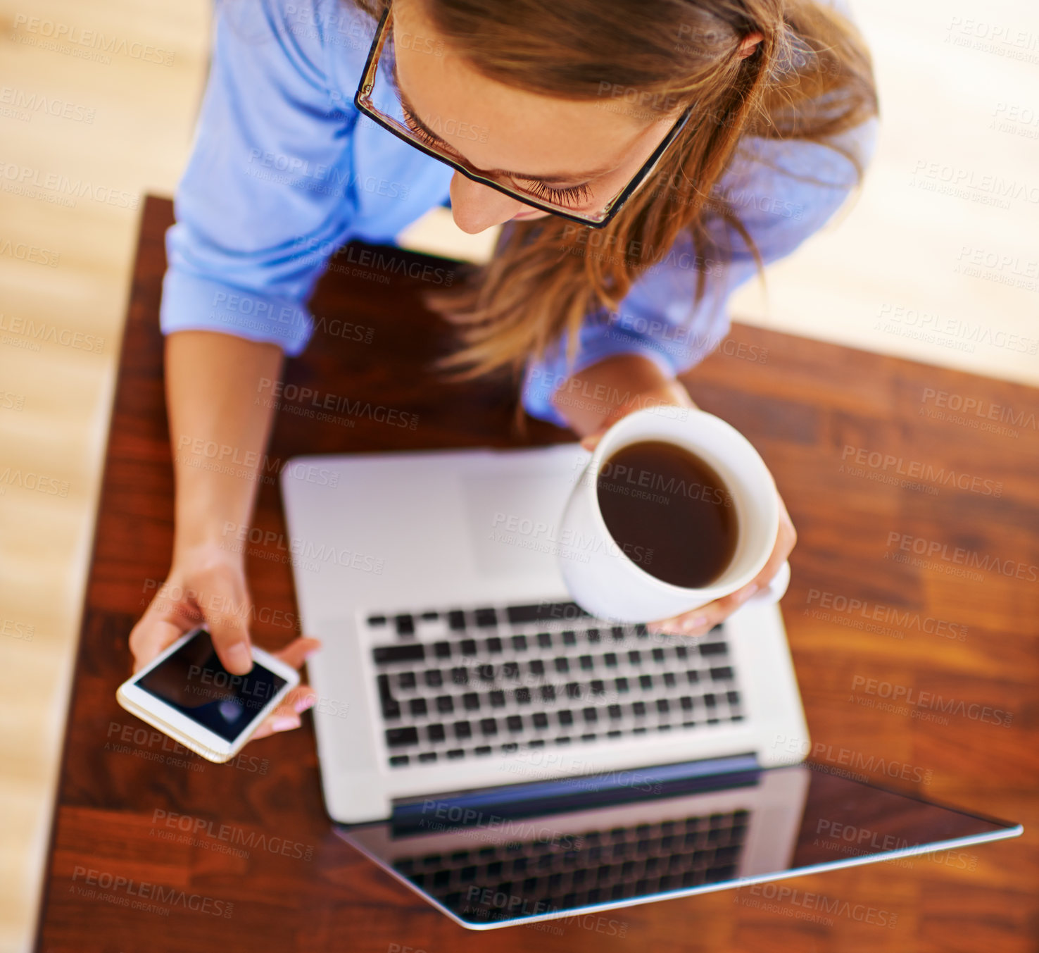 Buy stock photo Phone, coffee and above of woman on laptop in office for online research, website and social media. Creative worker, startup company and person on smartphone for internet, email and computer at desk