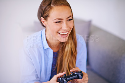 Buy stock photo Shot of a young woman holding a video game controller