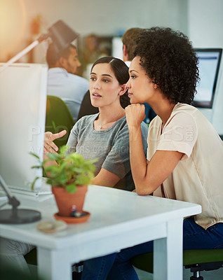 Buy stock photo Shot of designers talking together at a workstation in an office