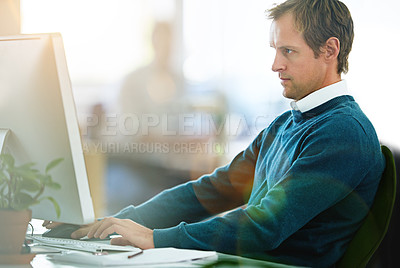 Buy stock photo Shot of a designer working at his computer in an office