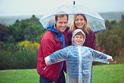 Buy stock photo Cropped portrait of a family of three standing outside in the rain