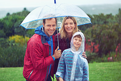 Buy stock photo Happy, rain and portrait of a family with umbrella outdoor in nature for fun, happiness and quality time. Man, woman and boy child together with water drops and freedom while playing on vacation