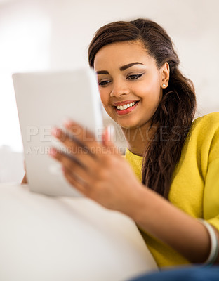 Buy stock photo Shot of a young woman using a digital tablet at home