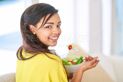 Buy stock photo Shot of a young woman eating a salad at home