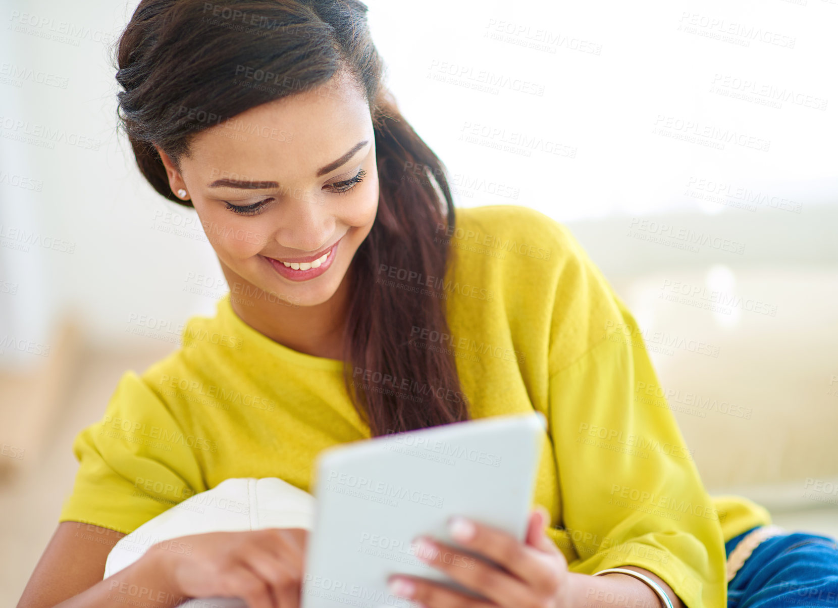 Buy stock photo Shot of a young woman using a digital tablet at home