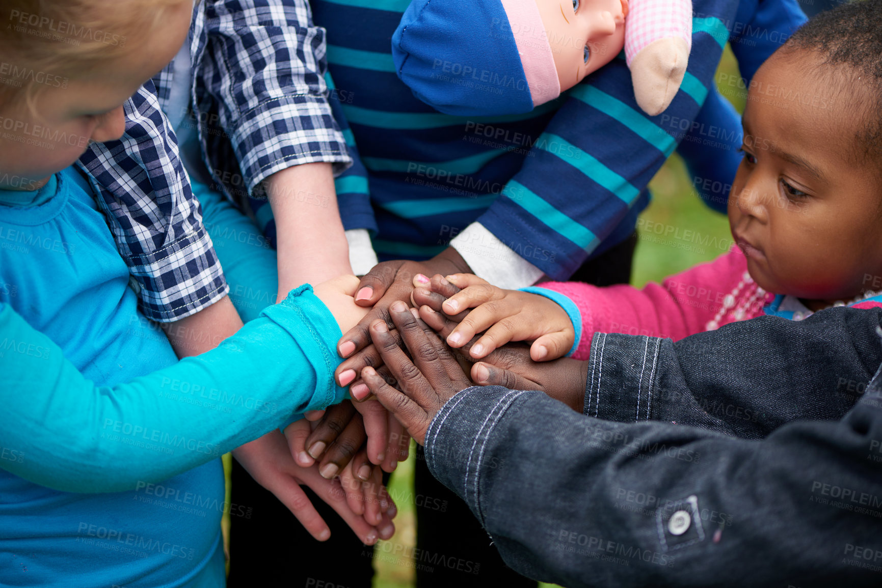 Buy stock photo Shot of a diverse group of children standing with their hands together