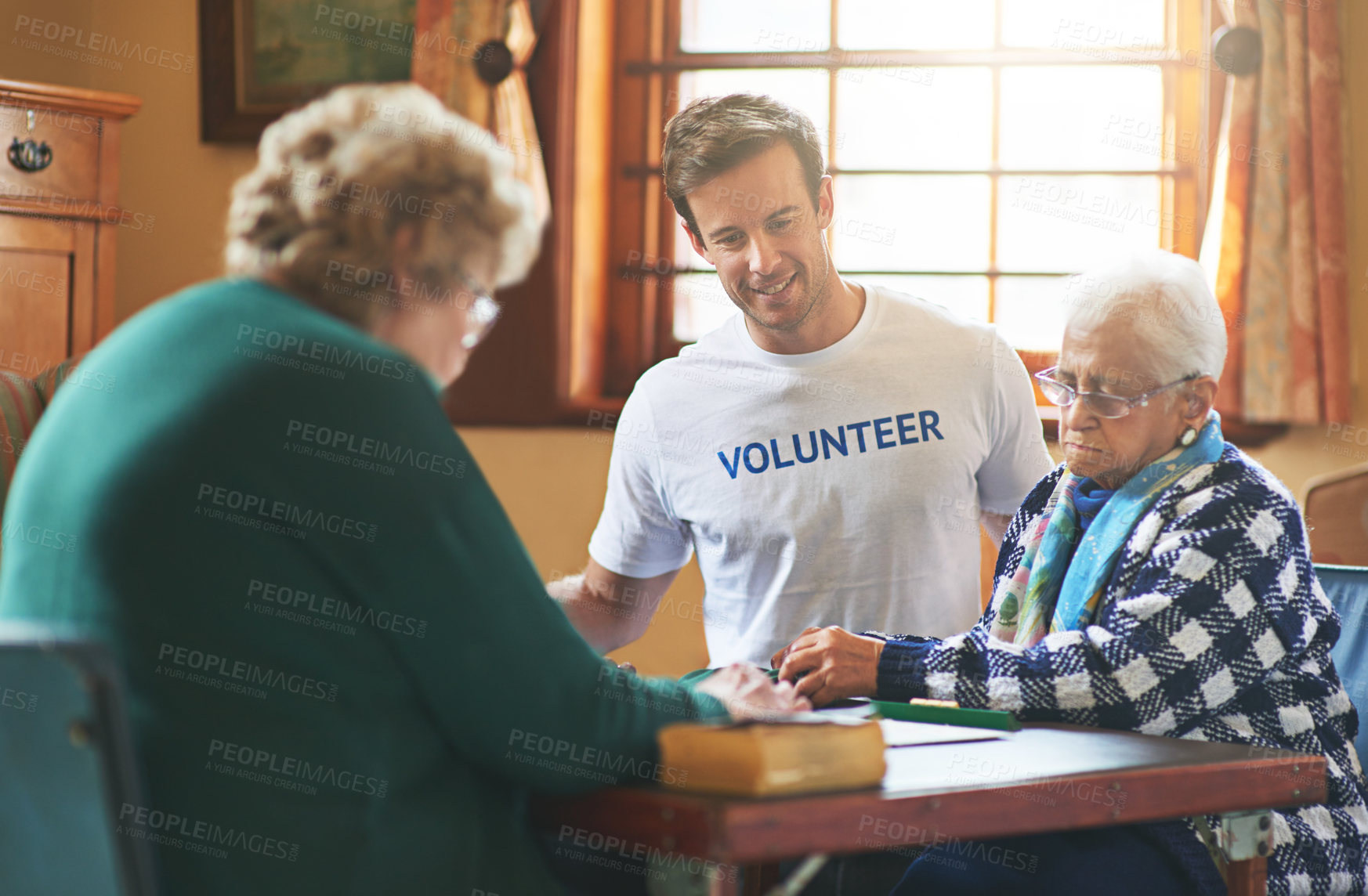 Buy stock photo Shot of a volunteer working with seniors at a retirement home