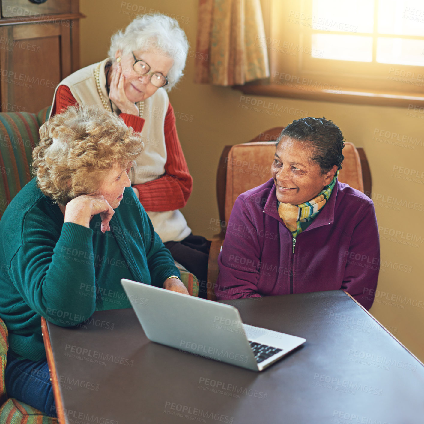 Buy stock photo Shot of a group of senior women using a laptop at a senior centre
