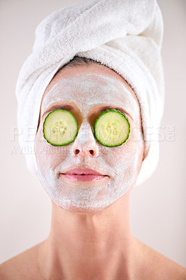 Buy stock photo Spa, woman and cucumber facial for skincare in studio with skin mask, organic detox or cosmetics with towel. Model, person or face with fruit for anti aging treatment or self care on white background