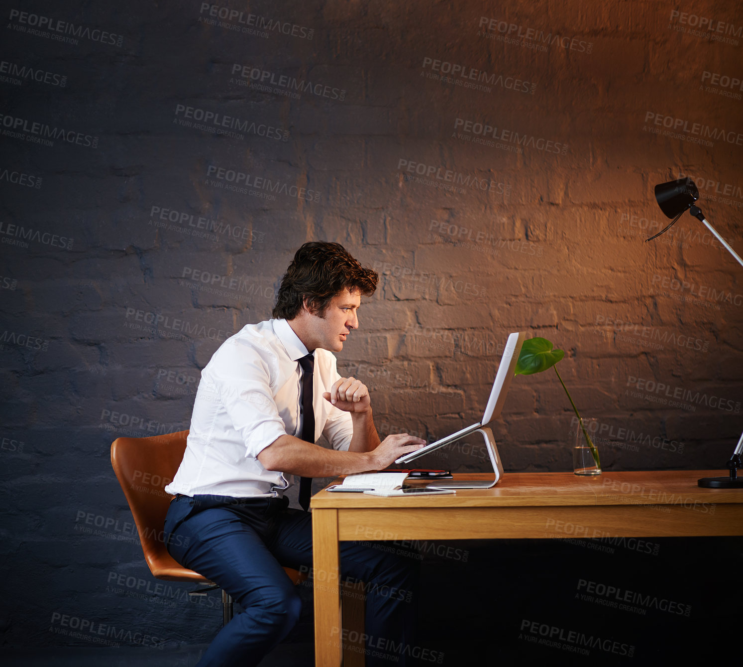 Buy stock photo Reading, laptop and businessman in office at night with report for investigation with research. Typing, computer and male detective working on criminal justice case for filing deadline by brick wall.