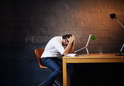 Buy stock photo Shot of a businessman looking exhausted after a long day at the office
