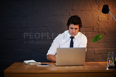 Buy stock photo Shot of a businessman working at his laptop after hours
