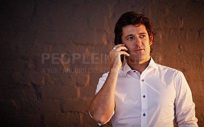 Buy stock photo Cropped shot of a businessman making a phone call after hours