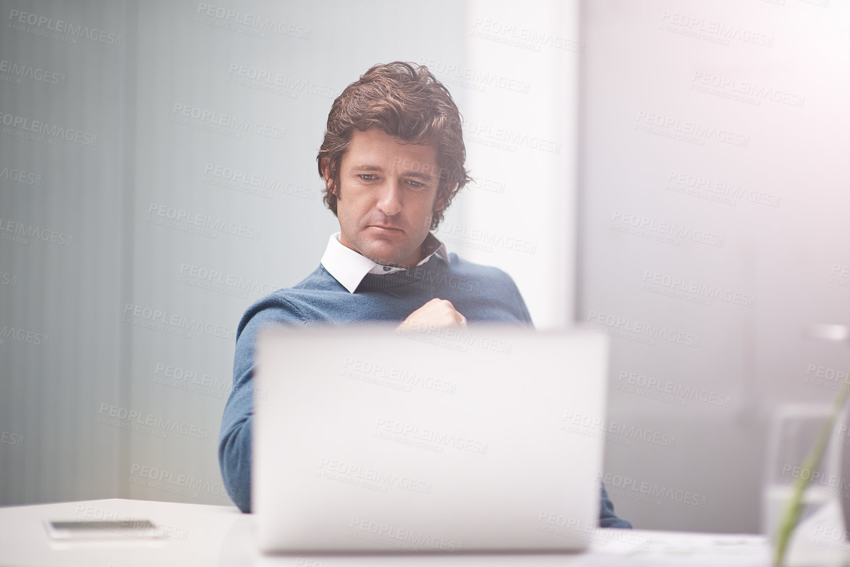 Buy stock photo Cropped shot of a businessman working on a laptop in an office