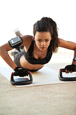 Buy stock photo Shot of a young woman exercising using push up grips