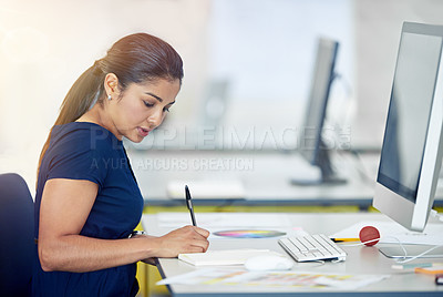 Buy stock photo Shot of a young woman working at her desk in an office