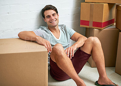 Buy stock photo Portrait of a young man sitting in his new home surrounded by cardboard boxes
