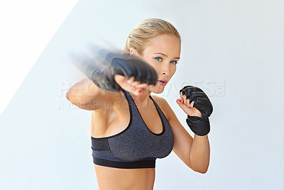 Buy stock photo Shot of a sporty young woman training with mma gloves