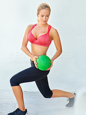 Buy stock photo Full length shot of a young woman working out with a medicine ball