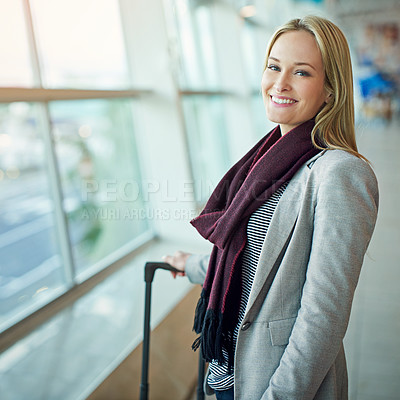 Buy stock photo Portrait of a young woman standing with her luggage in an airport
