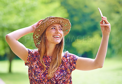 Buy stock photo Shot of a young woman taking a selfie in the park