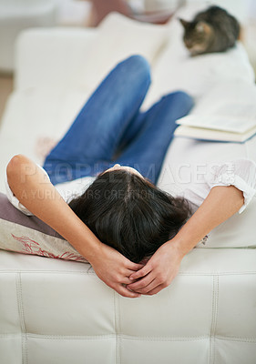 Buy stock photo Rearview shot of a young woman lying on her couch