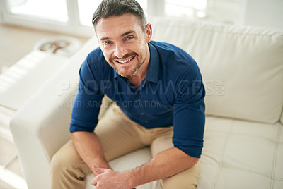 Buy stock photo Cropped portrait of a man sitting on the sofa at home