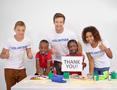 Buy stock photo Portrait of a volunteer holding up a 'thank you' sign while working with little children