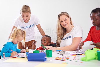 Buy stock photo Shot of volunteers working with little children