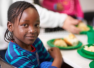 Buy stock photo Portrait of a little girl sitting at a dining table with food provided by volunteers