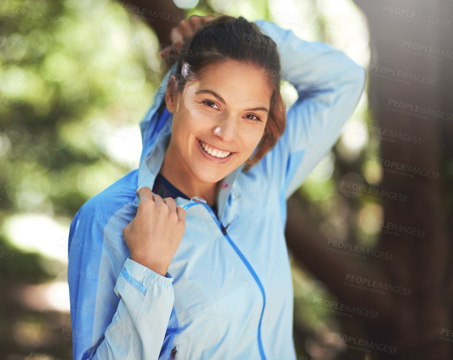 Buy stock photo Shot of a young woman warming up for a trail run