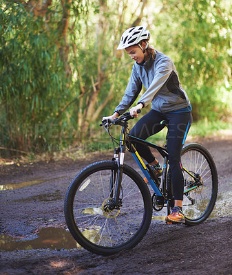 Buy stock photo Shot of a female mountain biker out for an early morning ride