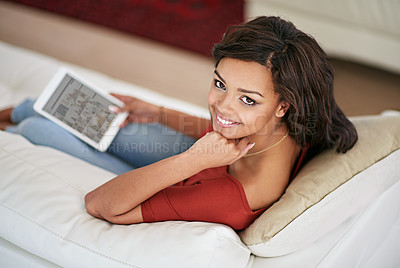 Buy stock photo Shot of a young woman using her digital tablet at home