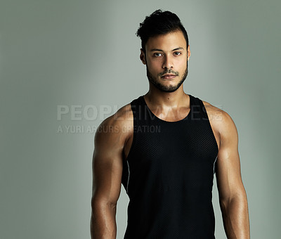 Buy stock photo Studio portrait of an athletic young man posing against a gray background