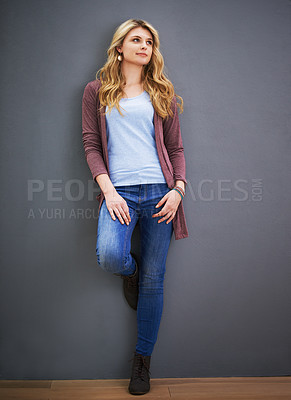 Buy stock photo Shot of a young woman standing against a gray background