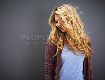 Buy stock photo Shot of a young woman standing against a gray background