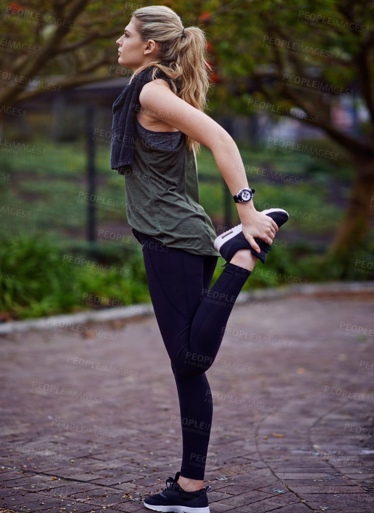 Buy stock photo Shot of a young woman stretching her legs before a run