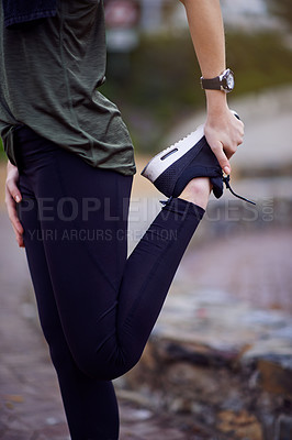 Buy stock photo Cropped shot of a young woman stretching her legs before a run