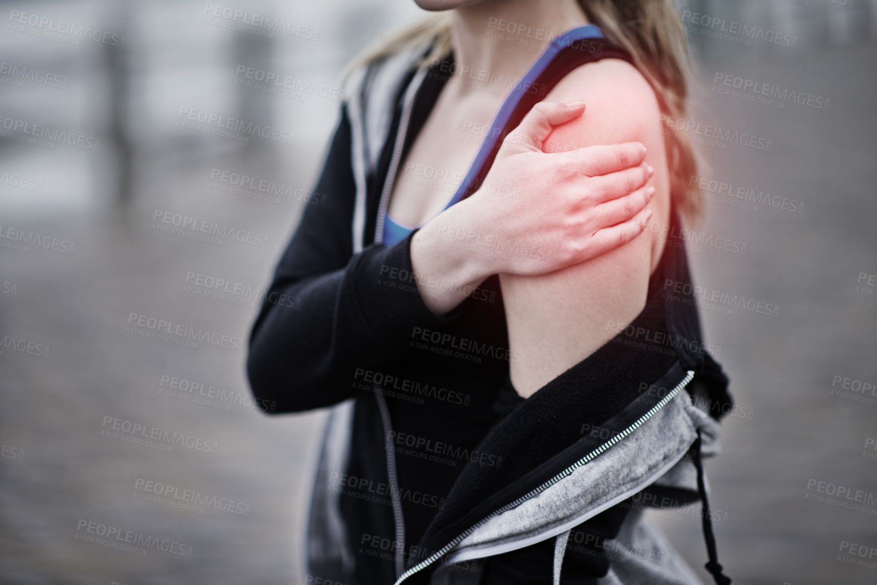 Buy stock photo Cropped shot of a young woman holding her injured shoulder