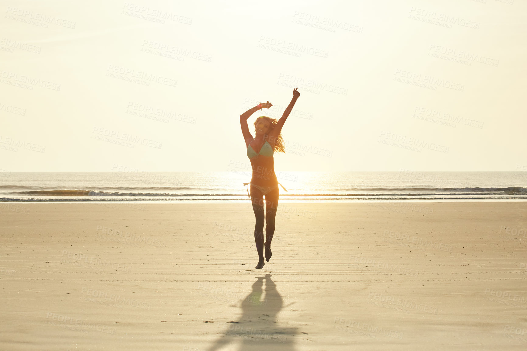 Buy stock photo Portrait of an attractive young woman running on the beach