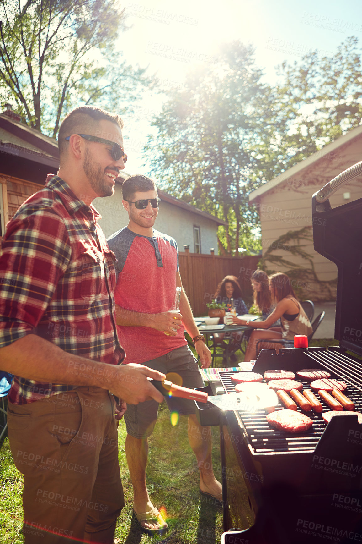 Buy stock photo Shot of friends having a barbecue outside