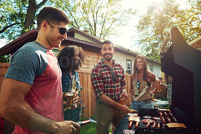 Buy stock photo Shot of a group of friends having a barbecue outside