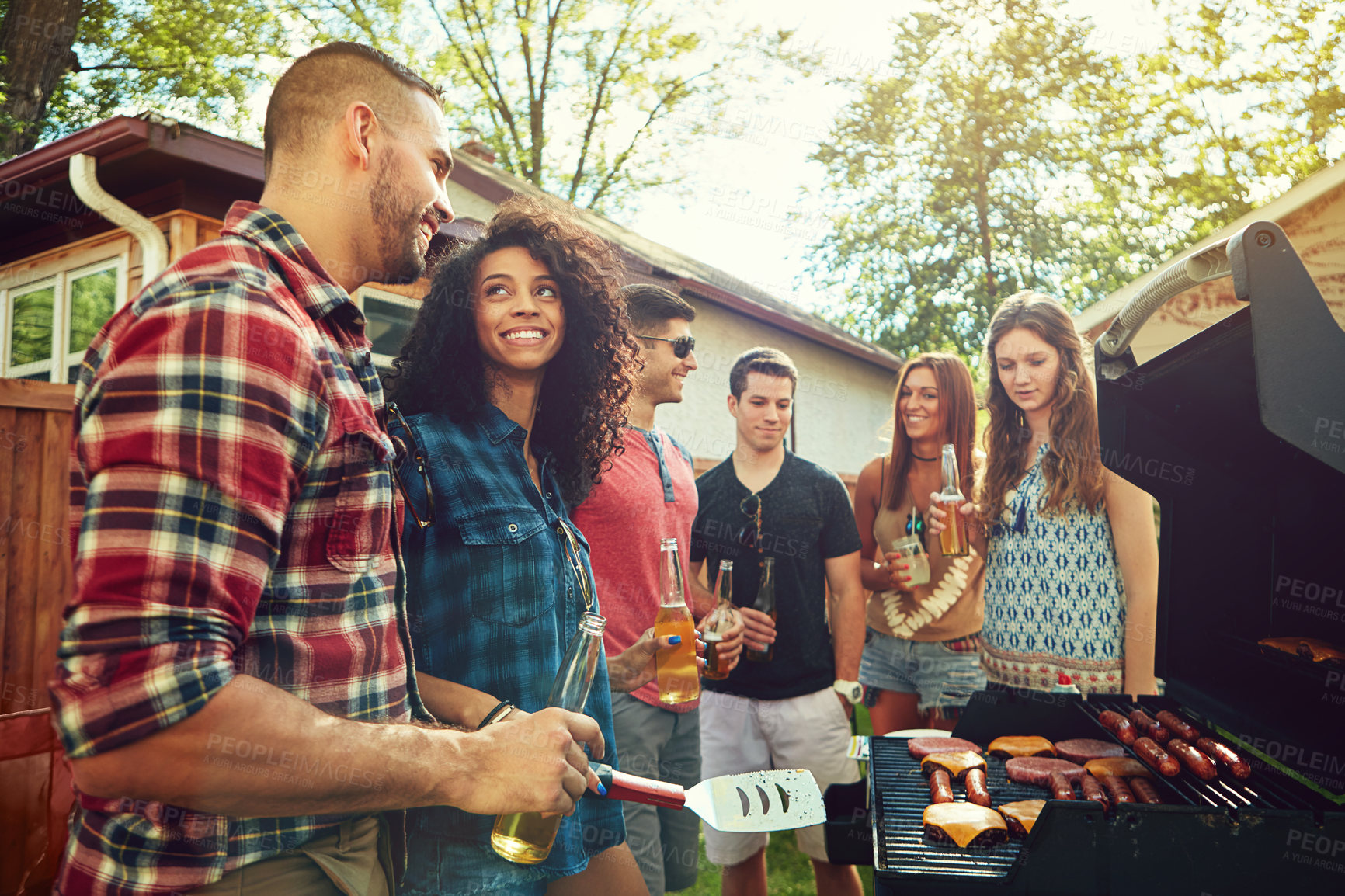 Buy stock photo Shot of a group of friends having a barbecue outside