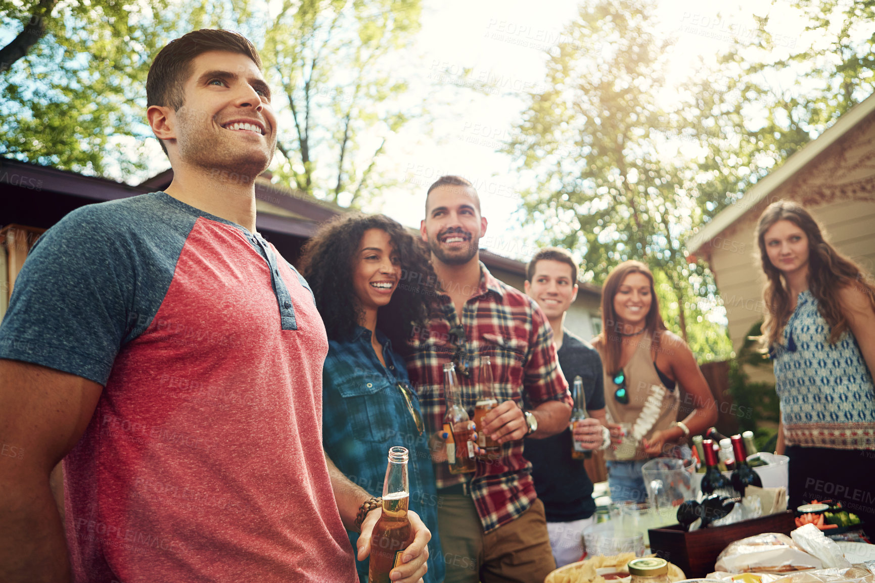 Buy stock photo Shot of a group of friends having lunch in their backyard