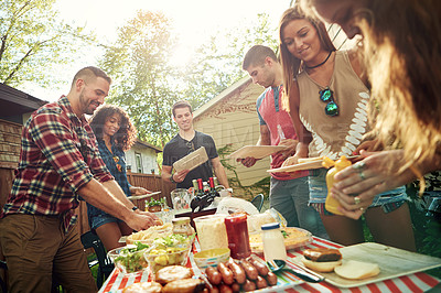 Buy stock photo Shot of a group of friends having lunch in their backyard