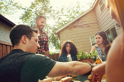 Buy stock photo Shot of a group of friends having lunch in their backyard