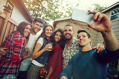 Buy stock photo Shot of a group of friends taking a selfie outside